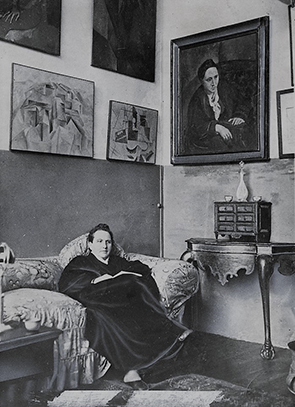 Gertrude Stein sitting with Picasso's portrait of her above